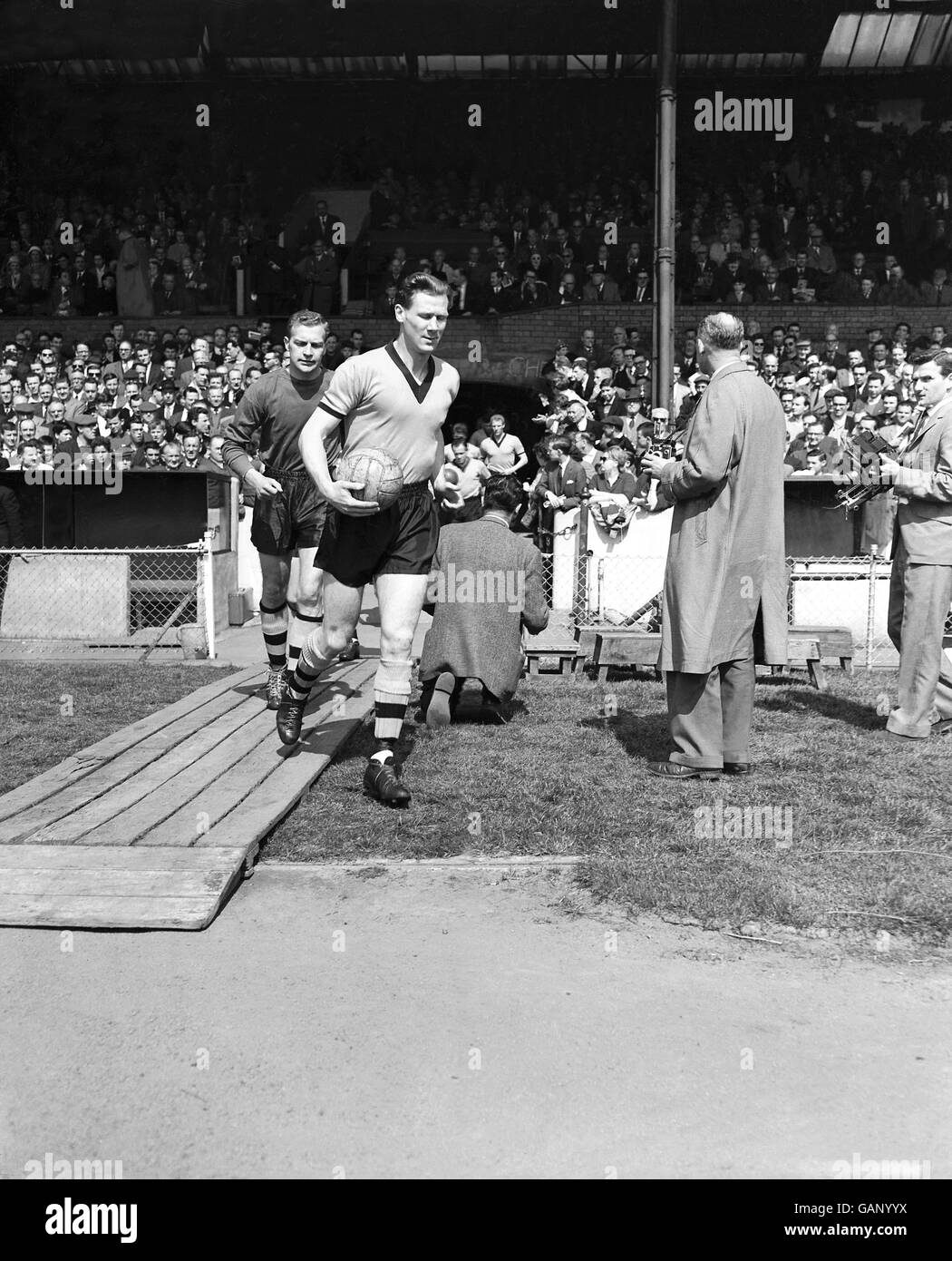 Bill Slater, capitano di Wolverhampton Wanderers, guida la sua squadra, seguito dal portiere Malcolm Finlayson Foto Stock