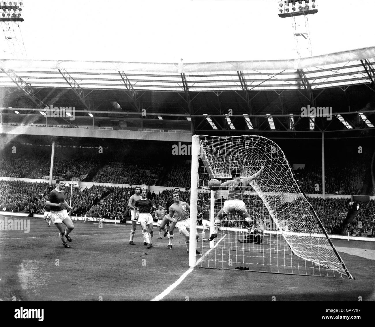 Eddie Reynolds di Wimbledon (secondo r, mezzo nascosto), che ha segnato tutti e quattro i gol della sua squadra con le intestazioni, guarda come Ted Sheppard di Sutton United (4) non riesce a cancellare il suo header fuori dalla linea di gol, dando a Wimbledon un vantaggio di 2-0 Foto Stock