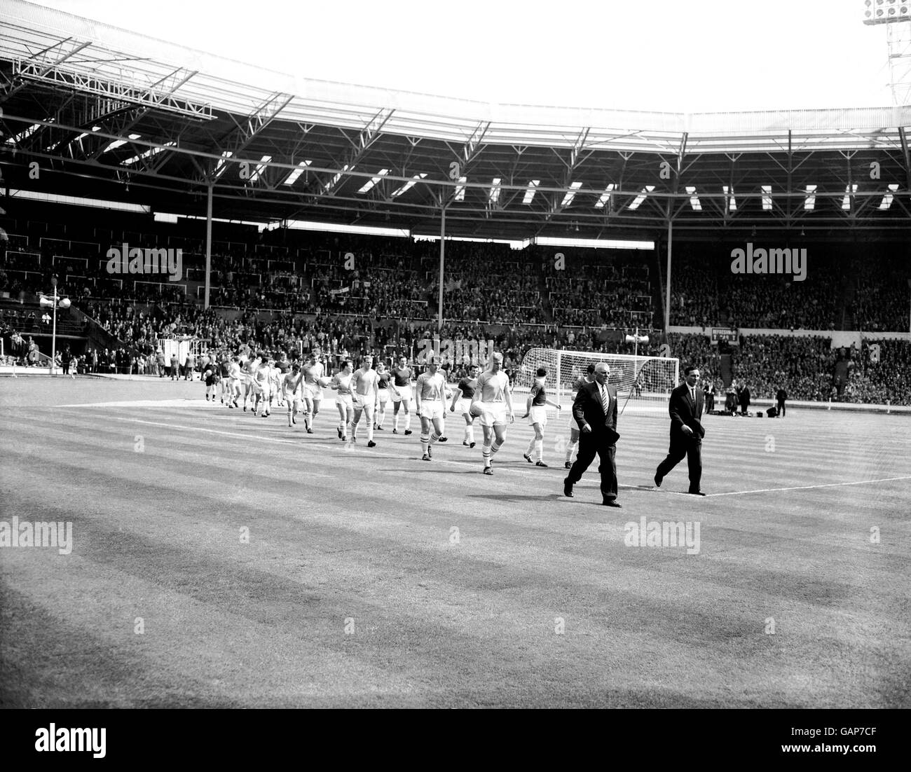 Le due squadre si fanno strada sul campo di Wembley prima della partita, Sutton Unito guidato dal manager Syd Cann (seconda r) e Wimbledon da allenatore Les Henly (r) Foto Stock