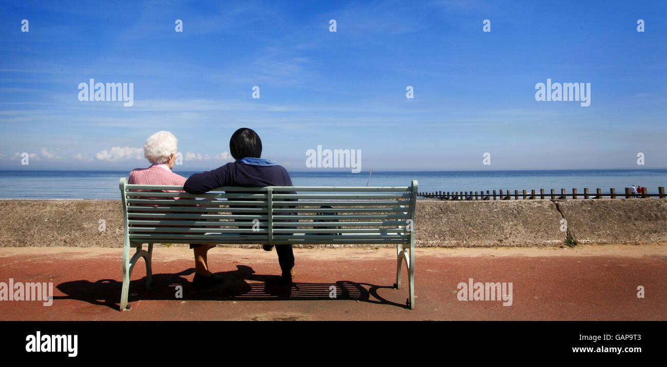 Due persone godono della vista sulla spiaggia di Portobello vicino a Edimburgo durante la calda vacanza in riva al mare. Foto Stock