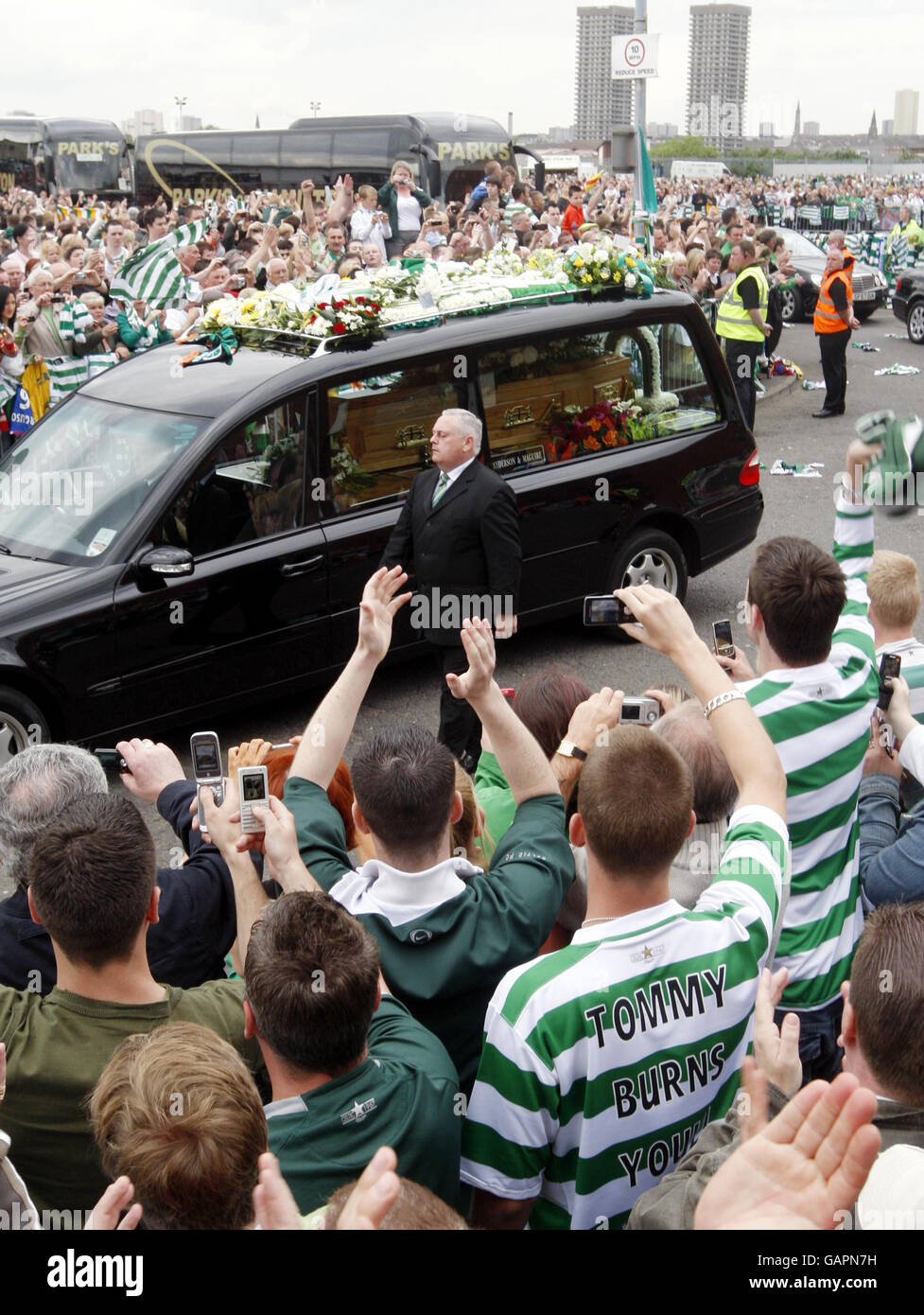La processione funeraria della leggenda celtica Tommy Burns oltrepassa il Celtic Park a Glasgow. Foto Stock