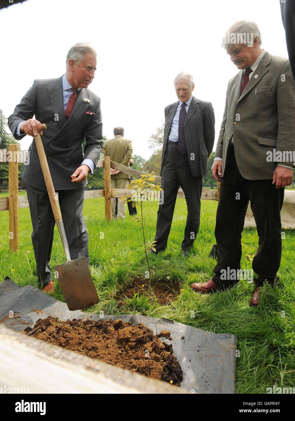 Il Principe del Galles (a sinistra) pianta un albero, guardato da Lord Lieut di Gloucestershire, Henry Elwes (centro), e il capo di Highgrove Gardener David Howard (a destra) nei terreni della sua casa durante una cerimonia di piantagione di alberi a Highgrove House, Gloucestershire. Foto Stock