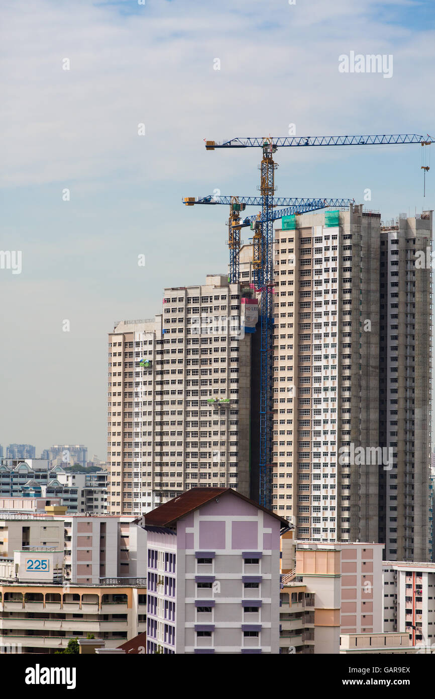 Vista verticale di vari lavori di costruzione industriale di blocchi e gru a torre. Singapore Foto Stock