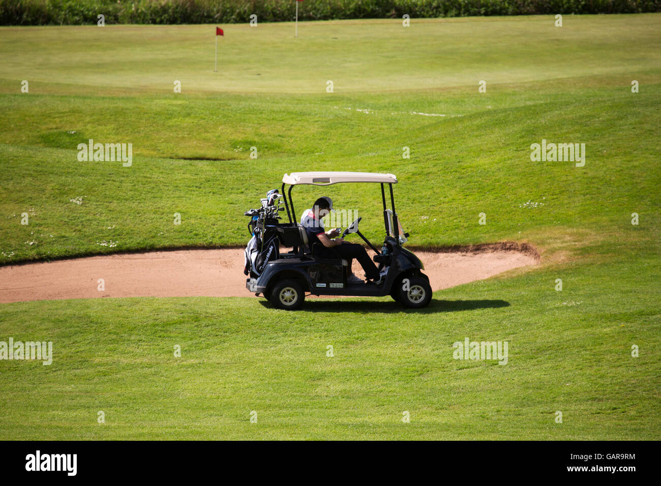 Gli amanti del golf su un campo da golf elettrico carrello. Non utilizzare il veicolo per il trasporto sul campo da golf. Foto Stock