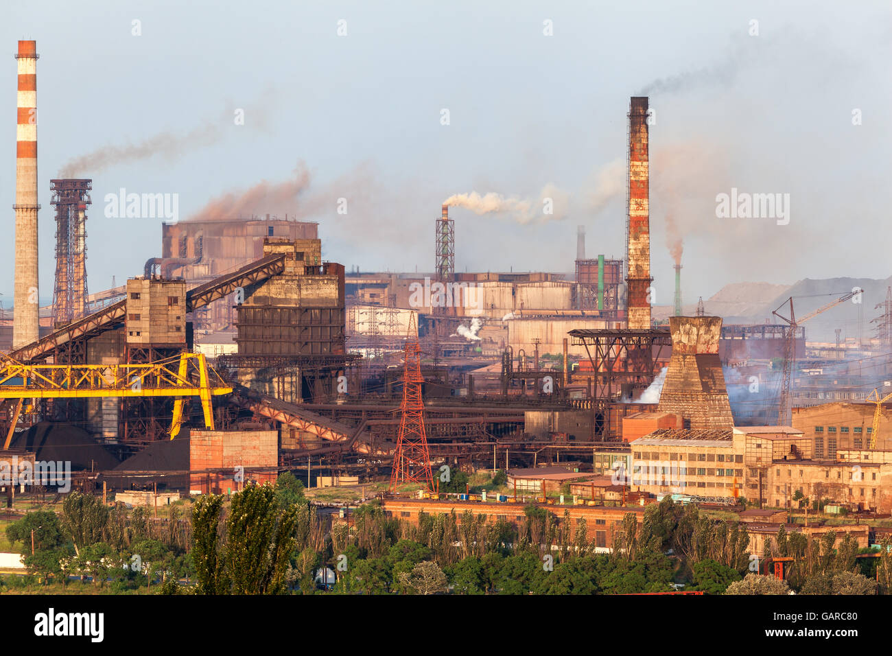 Fabbrica di acciaio con fumaioli al tramonto. stabilimento metallurgico. acciaierie e lavori di ferro. Industria pesante in Europa. Inquinamento atmosferico f Foto Stock