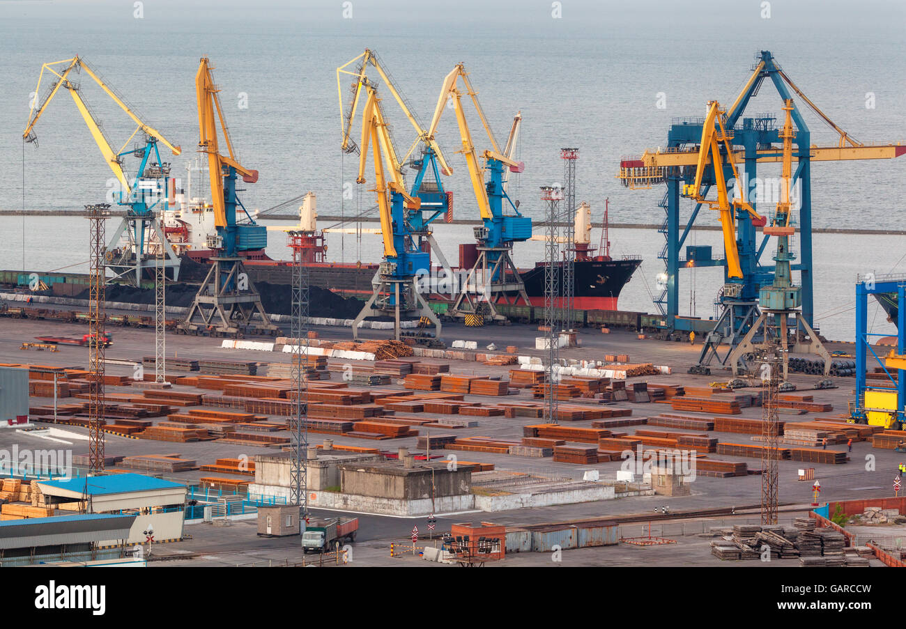 Porto commerciale di notte in Mariupol, Ucraina. Visione industriale. Merci spedite con gru di lavoro bridge nel porto di mare a Foto Stock
