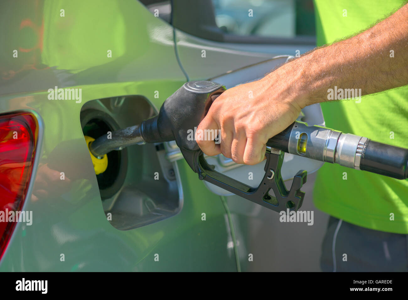 Il pompaggio del gas in corrispondenza della stazione di gas. In prossimità di una mano azienda ugello carburante. Foto Stock