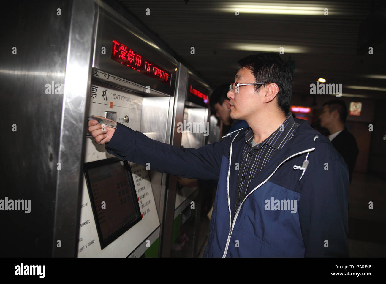 Un giovane uomo cinese messo i soldi di bill in biglietteria automatica per acquistare un biglietto della metropolitana. La metropolitana Zhongshan. Shanghai, Cina. Foto Stock Un giovane uomo cinese messo i soldi di bill in biglietteria automatica per acquistare un biglietto della metropolitana. La metropolitana Zhongshan. Shanghai, Cina. Foto Stock