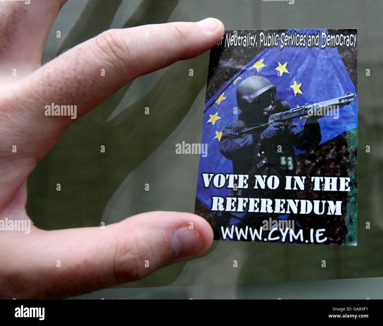 Un protestore mette in su gli adesivi che chiedono un no voto prima del referendum sul trattato di Lisbona nel centro di Dublino. Foto Stock