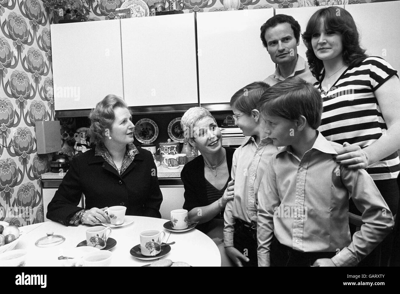 Il primo Ministro Margaret Thatcher (l), dopo aver consegnato una copia delle azioni di Amersham Road 39, Harold Hill al 12.000° acquirente di una casa del consiglio di Londra, James Patterson e sua moglie Maureen. Con loro sono i loro tre figli, gemelli Vernon e Martin e Leisa di 16 anni. Foto Stock