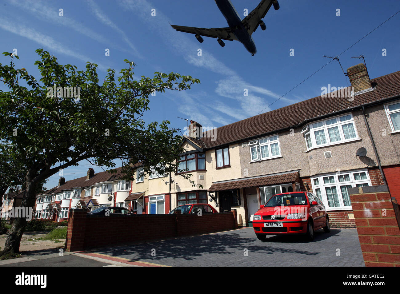 Una fotografia generica di un aereo che vola in basso su una proprietà di alloggi locali, sul suo approccio finale per atterrare a Heathrow Airpor Foto Stock