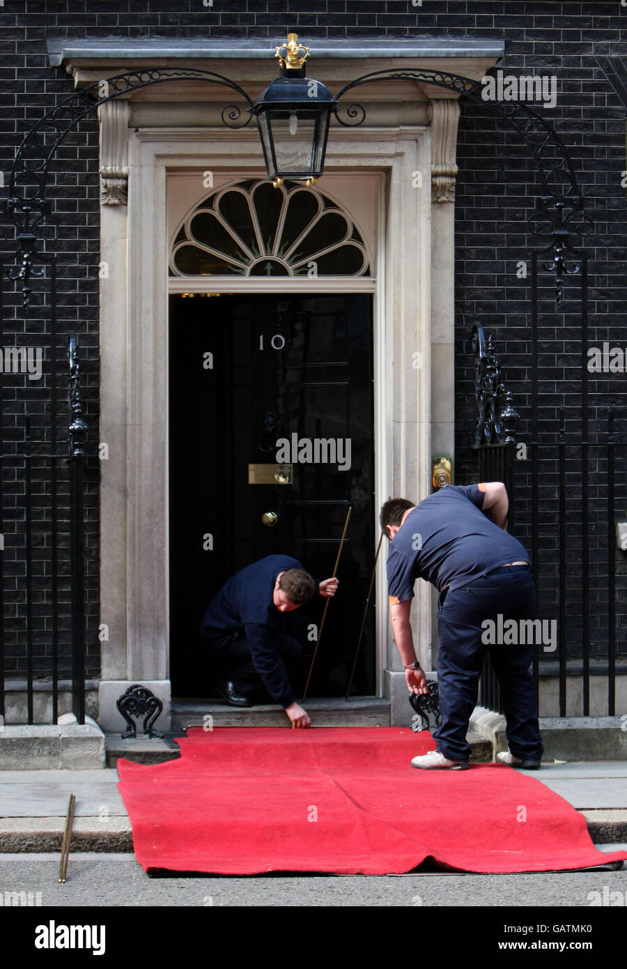 Il lavoratore ha messo un tappeto rosso fuori dal numero 10 Downing Street, Londra. Foto Stock