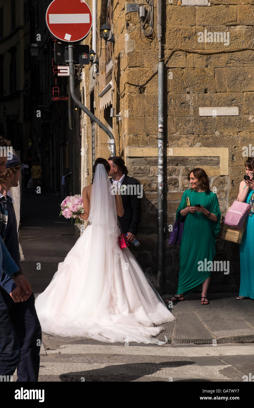 Sposa e lo sposo e gli amici su un angolo di strada in Firenze, Toscana, Italia. Foto Stock