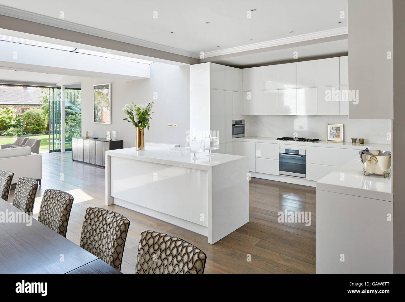 Vista obliqua verso la moderna cucina bianca interno fiera con pavimenti in legno. Casa privata, Highlever Road, Londra, Regno Unito. Architetto: Sophie Nguyen architetti, 2015. Foto Stock