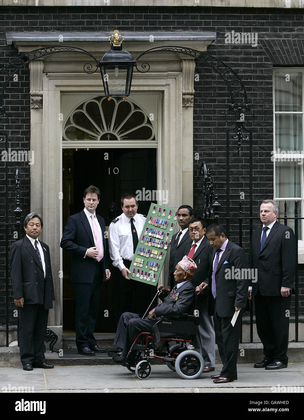 (Da sinistra a destra) il leader liberaldemocratico Nick Clegg si unisce a 87 anni, in pensione, il sergente regimentale Gurkha, il maggiore Pun Tulbahadur, attende fuori il n. 10 di Downing Street, mentre si prepara a restituire una serie delle sue medaglie al primo ministro per protestare contro le disuguaglianze pensionistiche subite da Gurkhas che si è Unito prima del 1997. Foto Stock