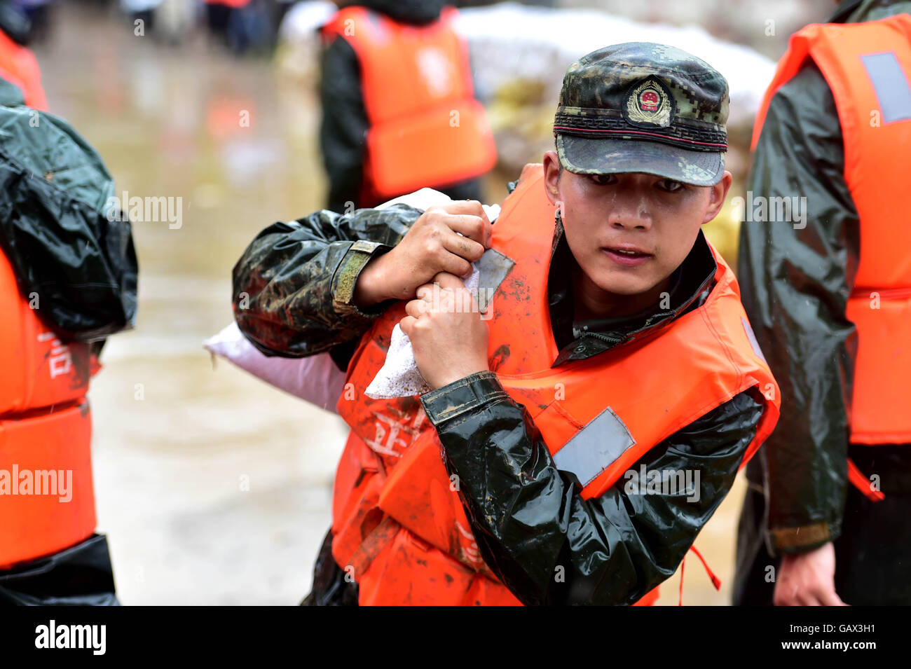 Zongyang, cinese della provincia di Anhui. 6 Luglio, 2016. Un soldato porta un sacco di sabbia per rinforzare il Dadao diga del lago Baidang in Tanggou township di Zongyang County, est cinese della provincia di Anhui, Luglio 6, 2016. Oltre 260 soldati sono stati spediti per rafforzare la diga. Credito: Liu Junxi/Xinhua/Alamy Live News Foto Stock