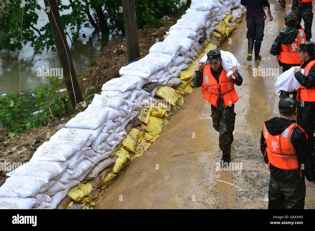 Zongyang, cinese della provincia di Anhui. 6 Luglio, 2016. Un soldato porta un sacco di sabbia per rinforzare il Dadao diga del lago Baidang in Tanggou township di Zongyang County, est cinese della provincia di Anhui, Luglio 6, 2016. Oltre 260 soldati sono stati spediti per rafforzare la diga. Credito: Liu Junxi/Xinhua/Alamy Live News Foto Stock