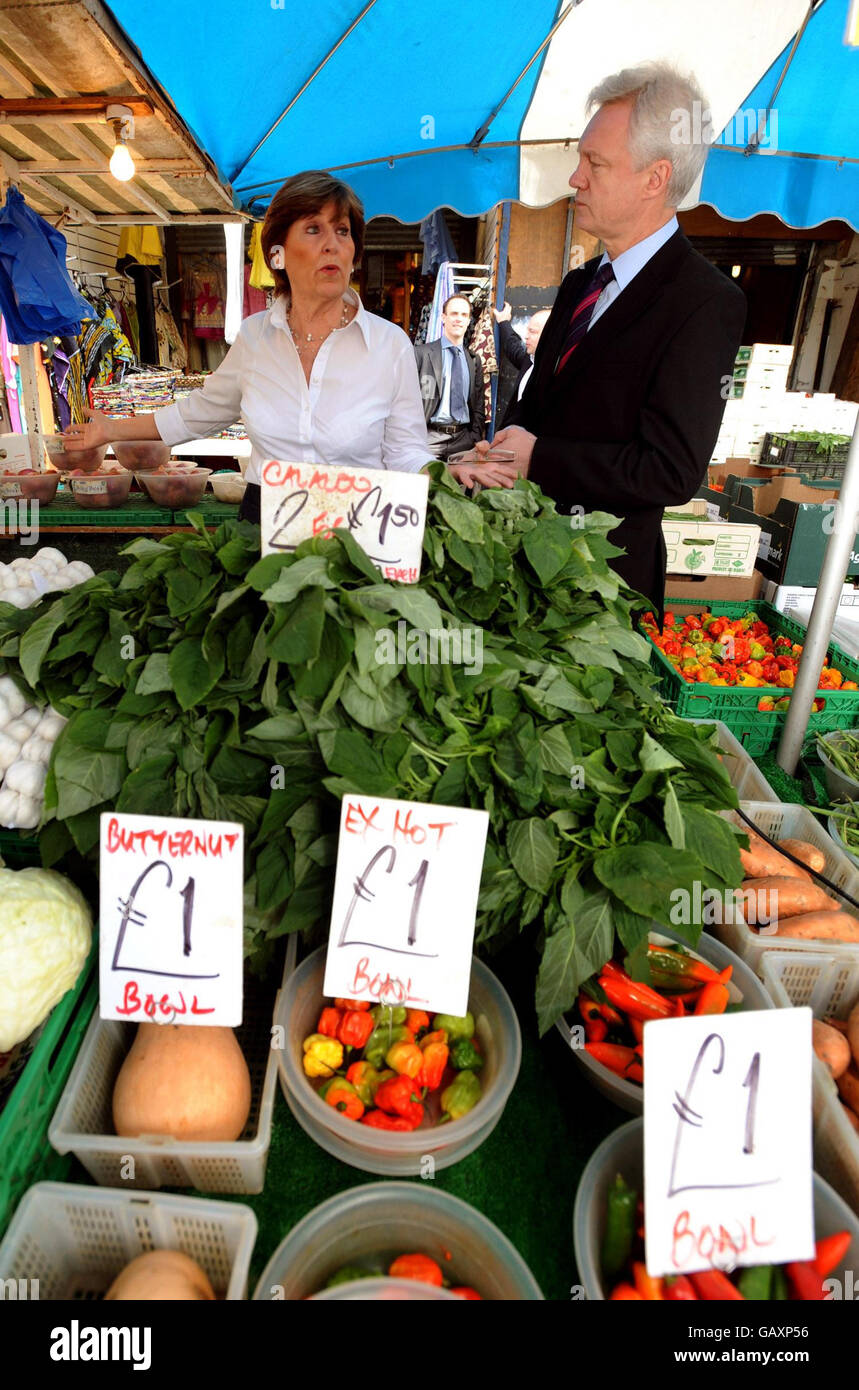 Il deputato conservatore David Davis si è dimesso con Janet Devers nel suo stand di frutta e verdura sul mercato di Ridley Road a Hackney, a est di Londra. Foto Stock