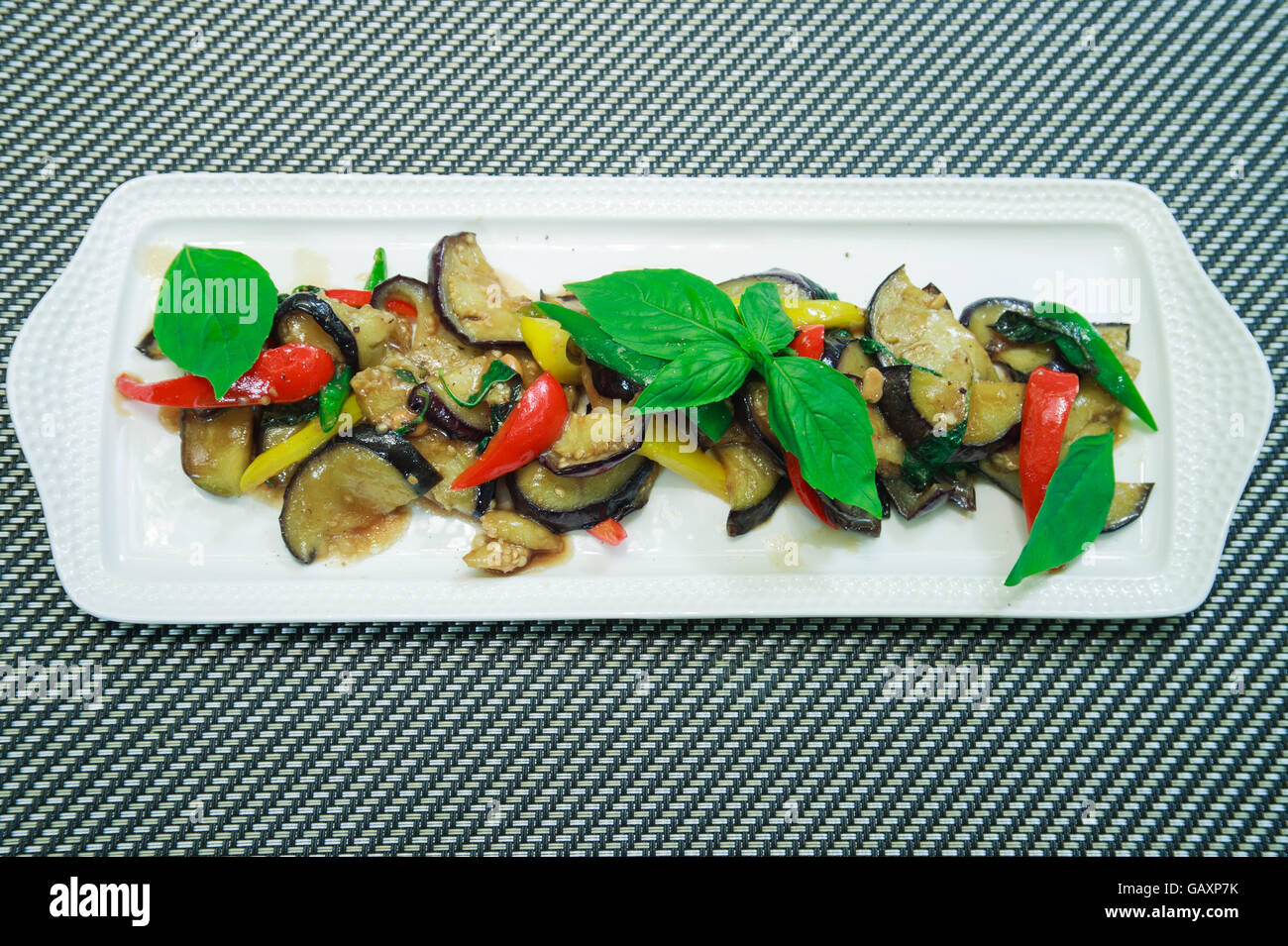 Cibo vegetariano in stile Tailandese Stir-Fry di Melanzane con pasta di fagioli e chillli, basilico tailandese. Foto Stock
