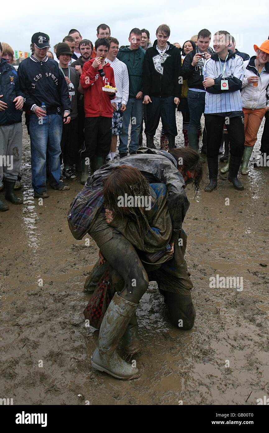 Gli amanti del festival lottano nel fango durante l'Oxegen Festival 2008 presso l'ippodromo di Punchestown, Naas, County Kildare, Irlanda. Foto Stock