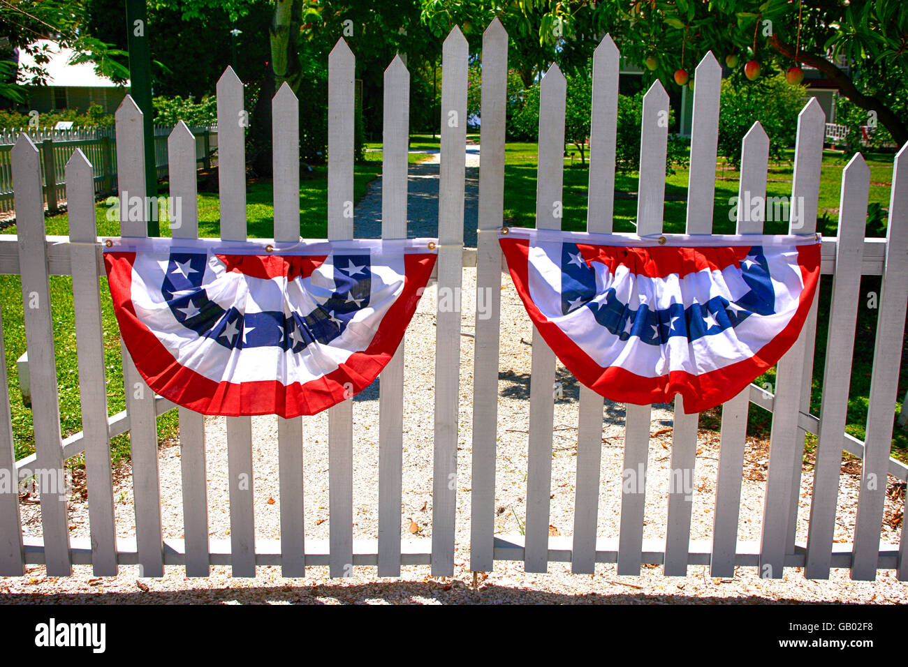 White Picket Fence gates con 4 luglio rosso, bianco e blu bunting celebra il giorno di indipendenza in Florida Foto Stock