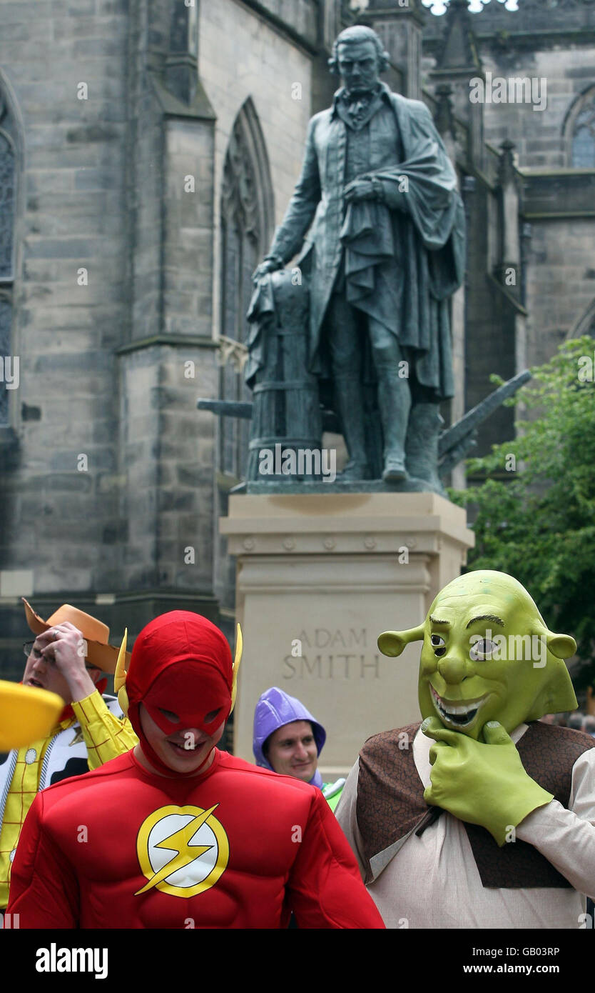 Una festa di pugnalata passa davanti al primo monumento pubblico al mondo per l'economista e filosofo scozzese Adam Smith sul Royal Mile di Edimburgo. Foto Stock