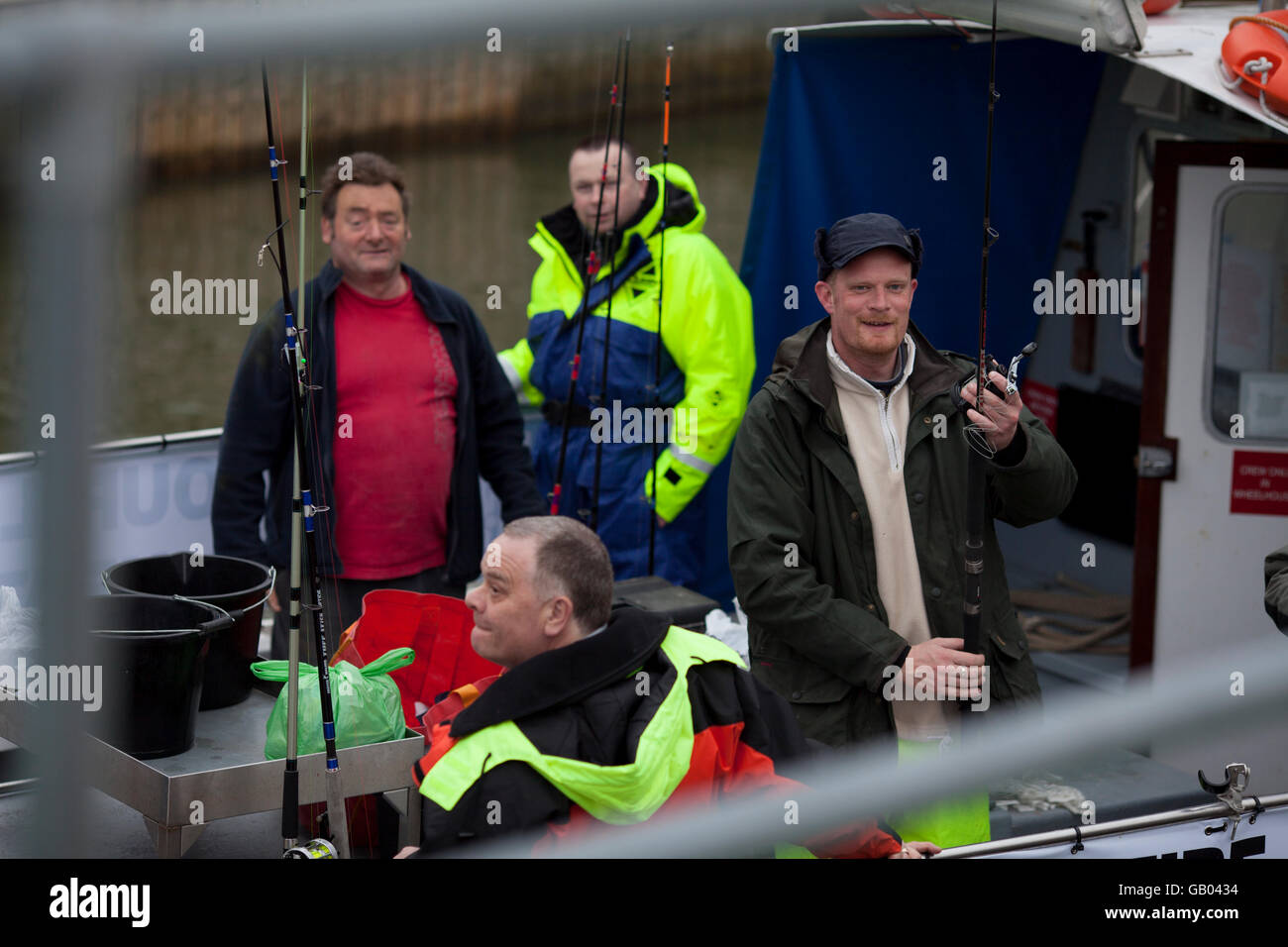 Quattro uomini su una barca da pesca Foto Stock