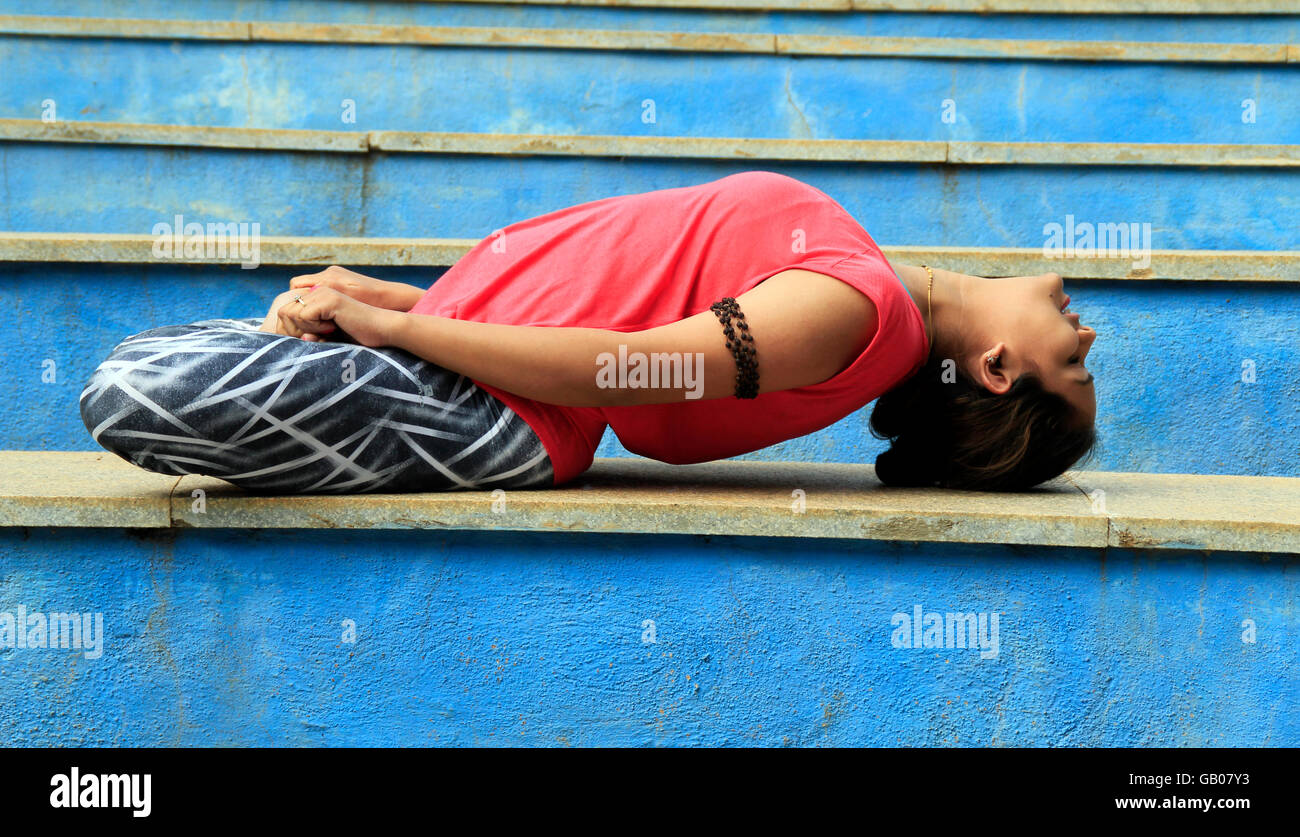 Giovane donna eseguendo il matsyasana o la posa di pesce Foto Stock