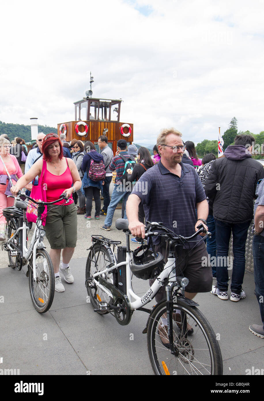 FreeGo biciclette elettriche ebikes arrivando a Bowness sul Lago di Windermere dopo una crociera sul Lago Foto Stock