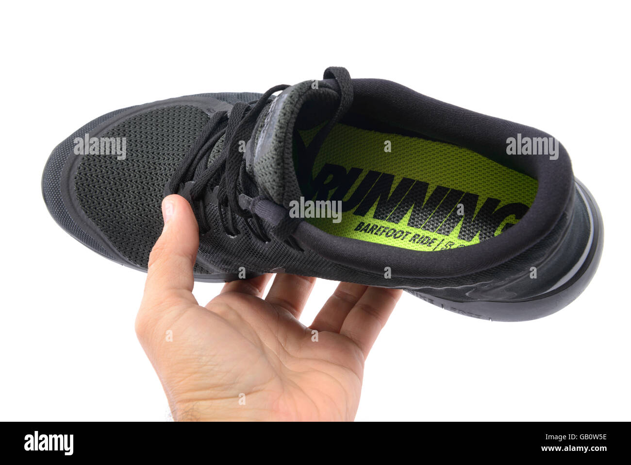 Persona in possesso di un Nike Free 5.0 Corsa a piedi nudi black scarpa da corsa Foto Stock
