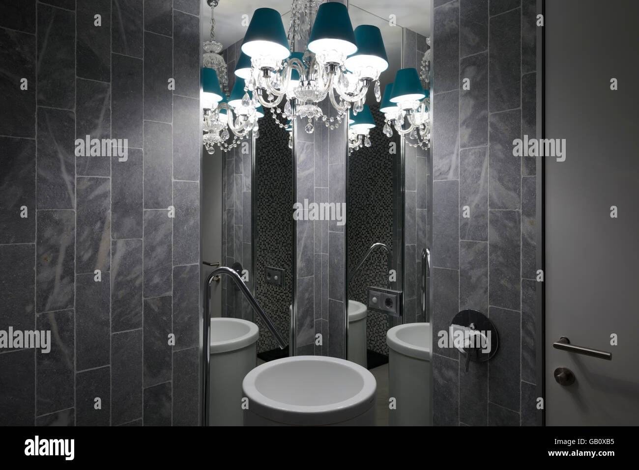 Lampadario e bacino idrico con due specchi su un bagno di fantasia Foto Stock