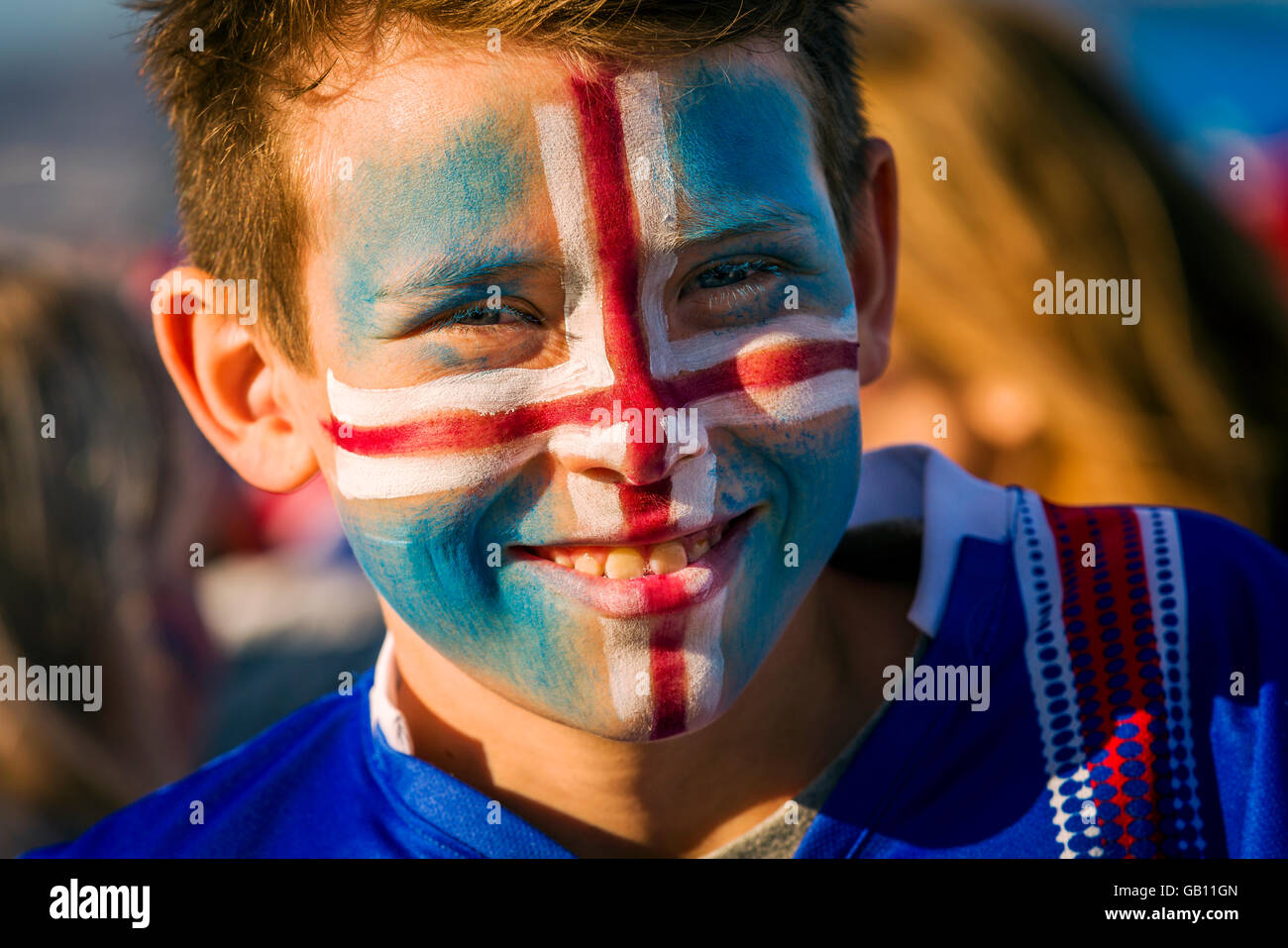 Ragazzo con faccia dipinta, sostenendo in Islanda in UEFA EURO 2016 torneo di calcio, Reykjavik, Islanda. Foto Stock