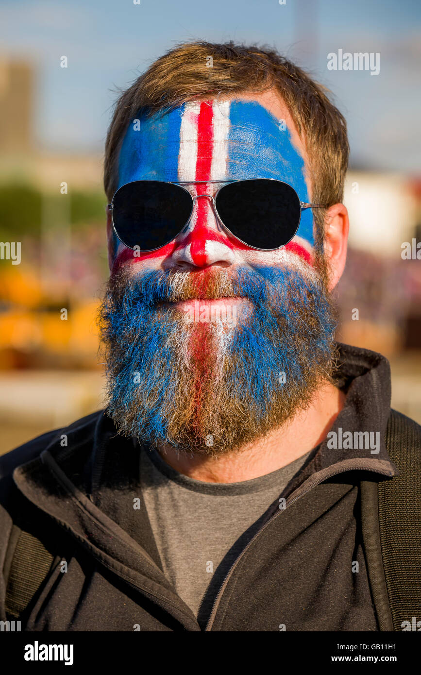 L'uomo con la faccia dipinta, sostenendo in Islanda in UEFA EURO 2016 torneo di calcio, Reykjavik, Islanda. Foto Stock