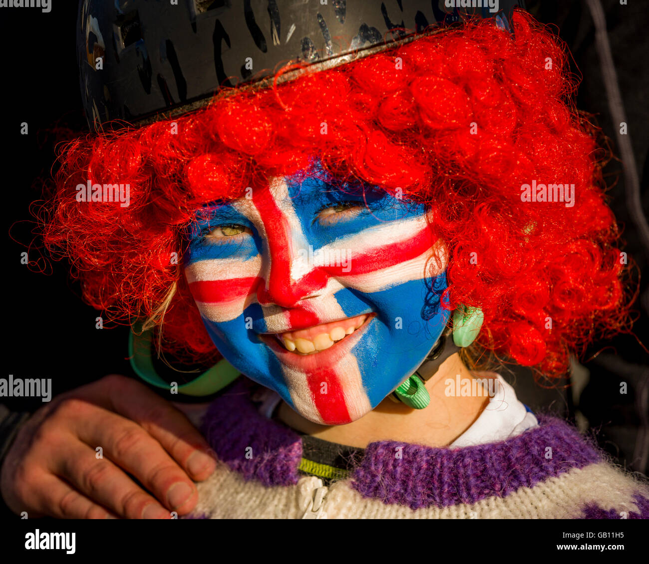 Ragazza con faccia dipinta, sostenendo in Islanda in UEFA EURO 2016 torneo di calcio, Reykjavik, Islanda. Foto Stock