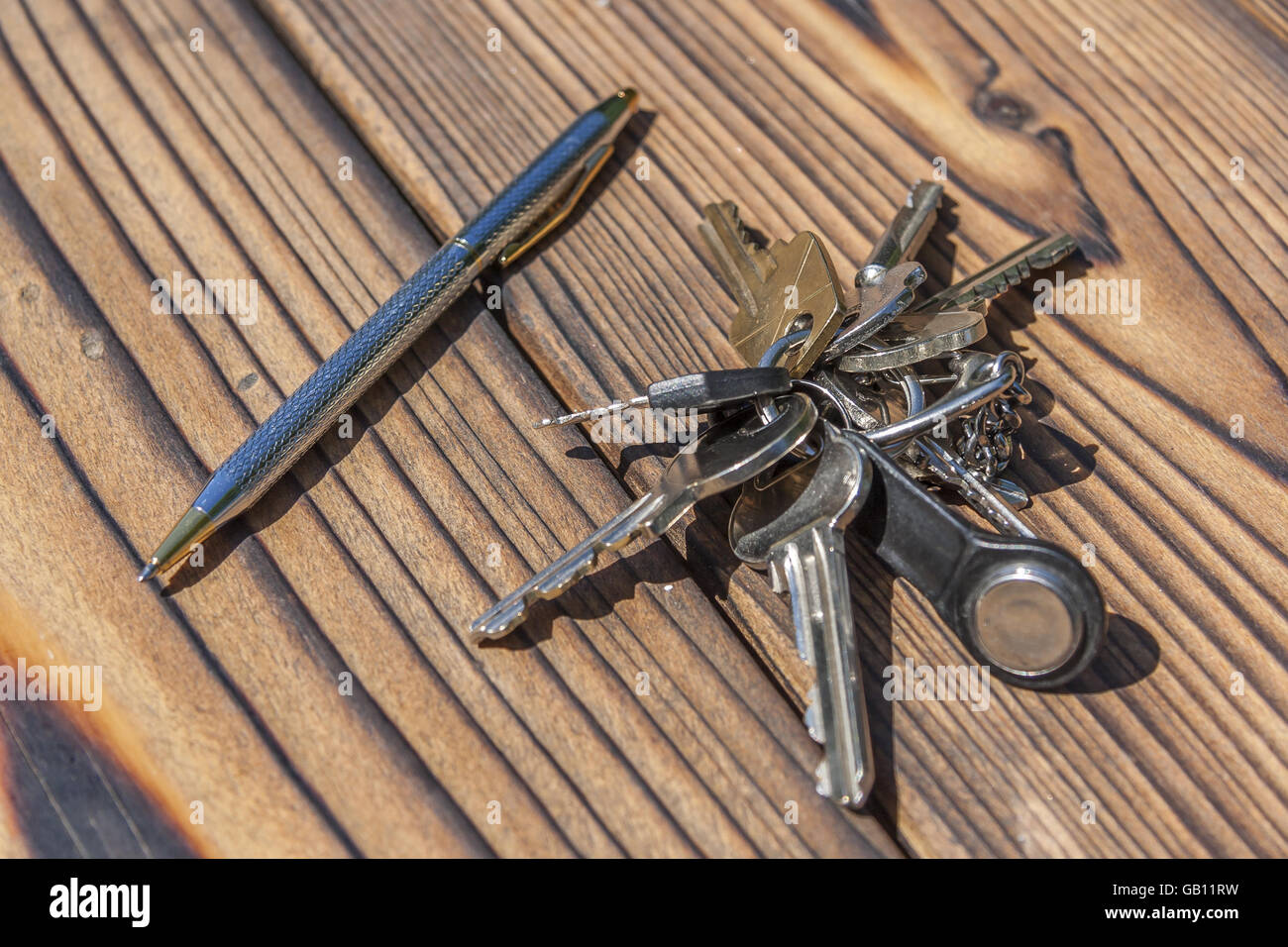 Penna e le chiavi di casa su una scrivania in legno Foto Stock