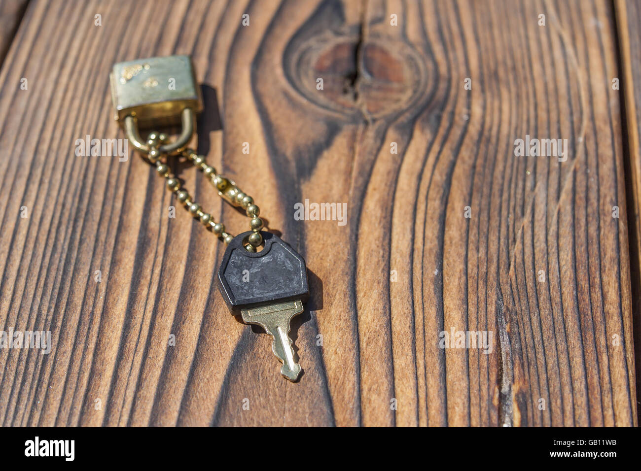 Chiave e lucchetto sulla tavola di legno Foto Stock