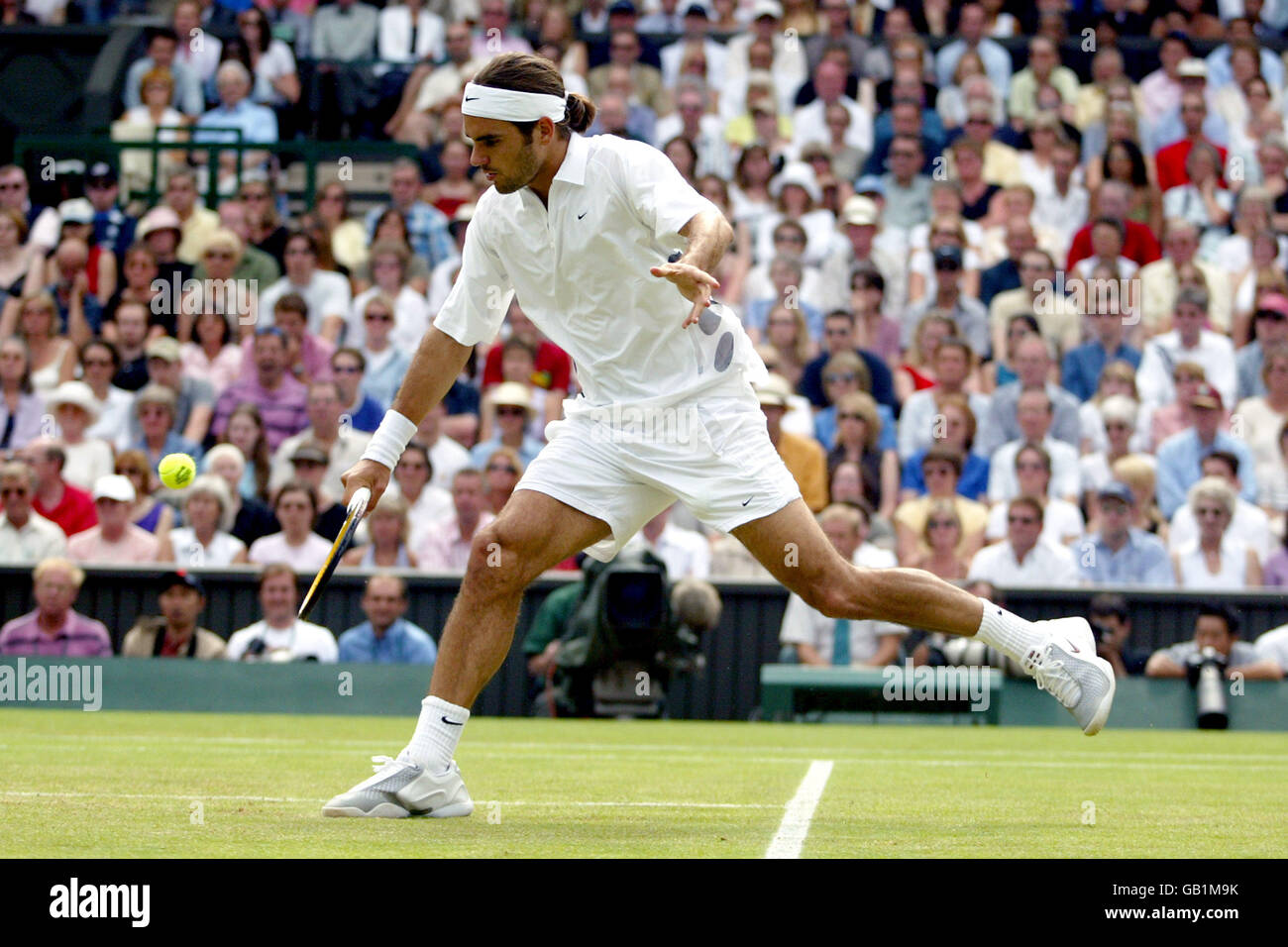 Tennis - Wimbledon 2003 - finale maschile - Mark Philippoussis contro Roger Federer. Roger Federer raggiunge per un volley Foto Stock