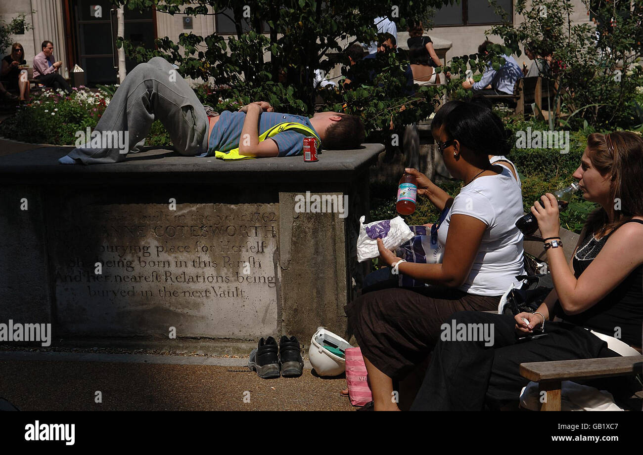 Un uomo dorme nel caldo del sole a Fen Court, città di Londra. Foto Stock