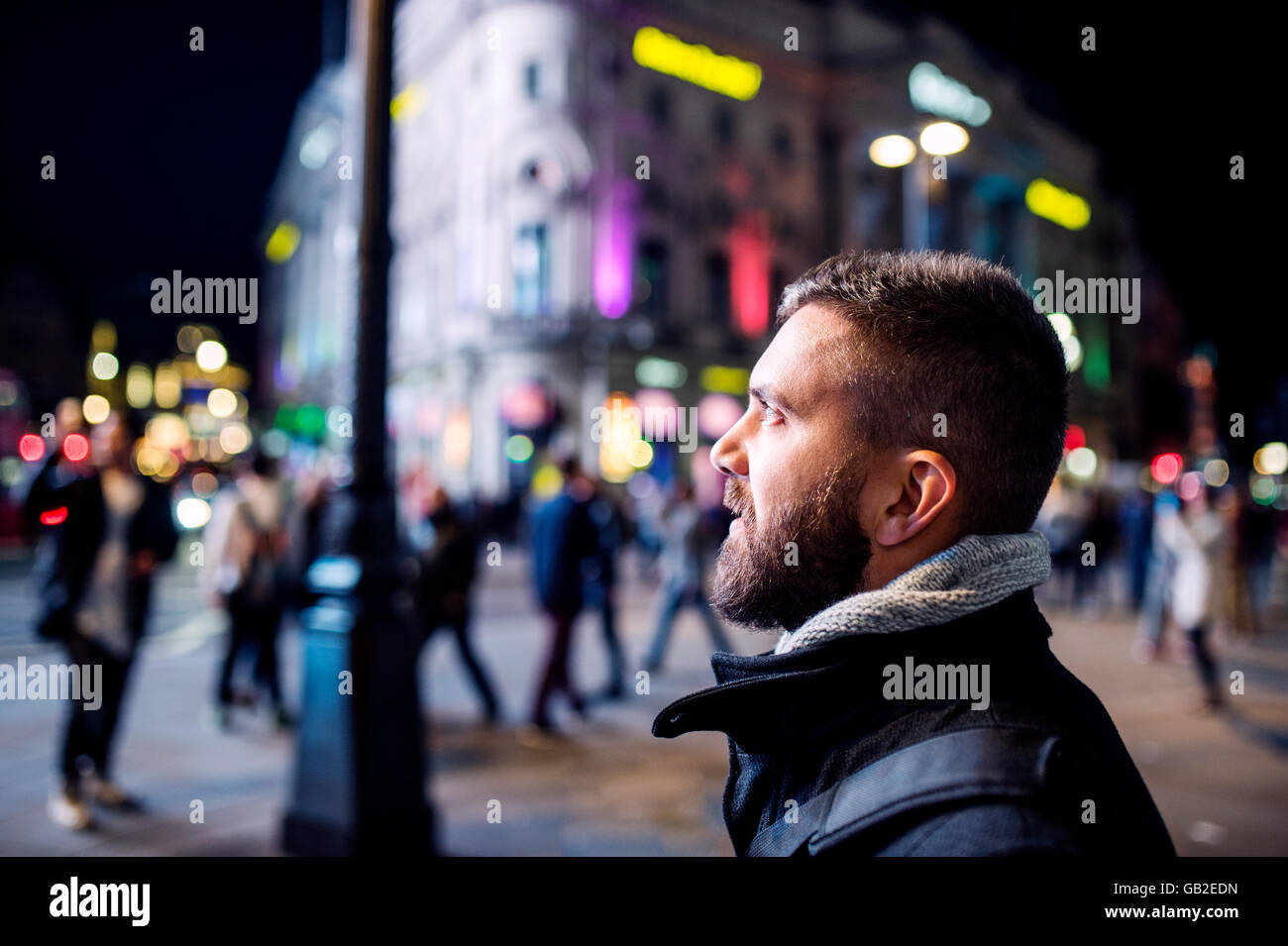 Uomo a camminare per le strade di Londra di notte Foto Stock