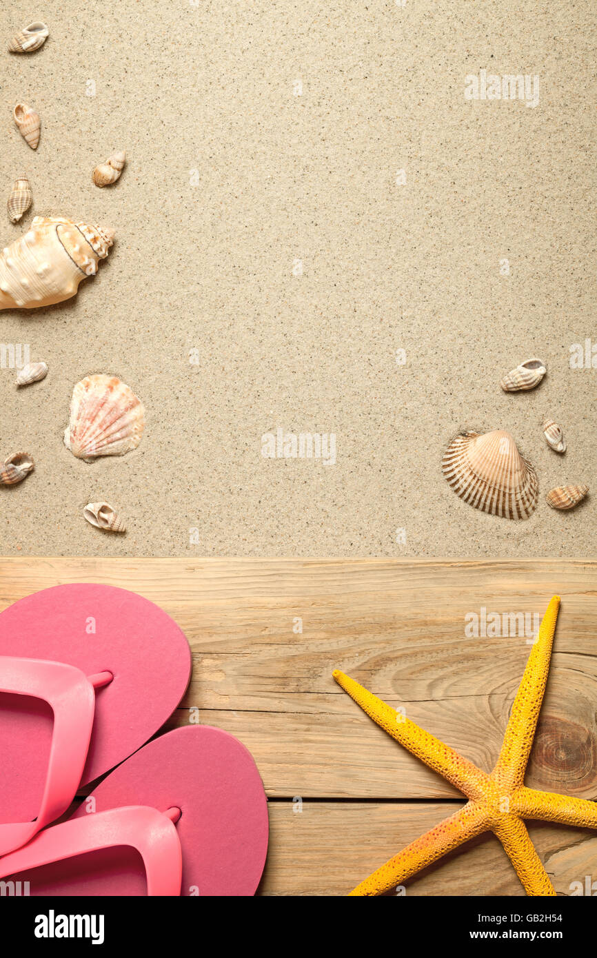 Concetto di estate con rosa flip flop, giallo di stelle marine e conchiglie sulla spiaggia sabbiosa. Vista superiore Foto Stock