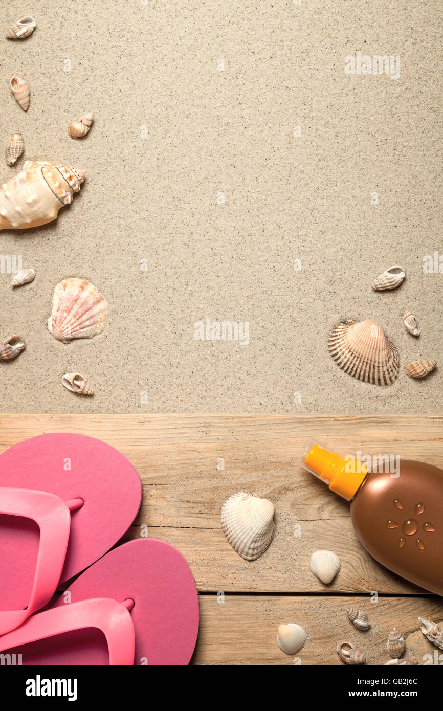 Concetto di estate con rosa flip flop, conchiglie e olio di abbronzarvi sulla spiaggia sabbiosa Foto Stock