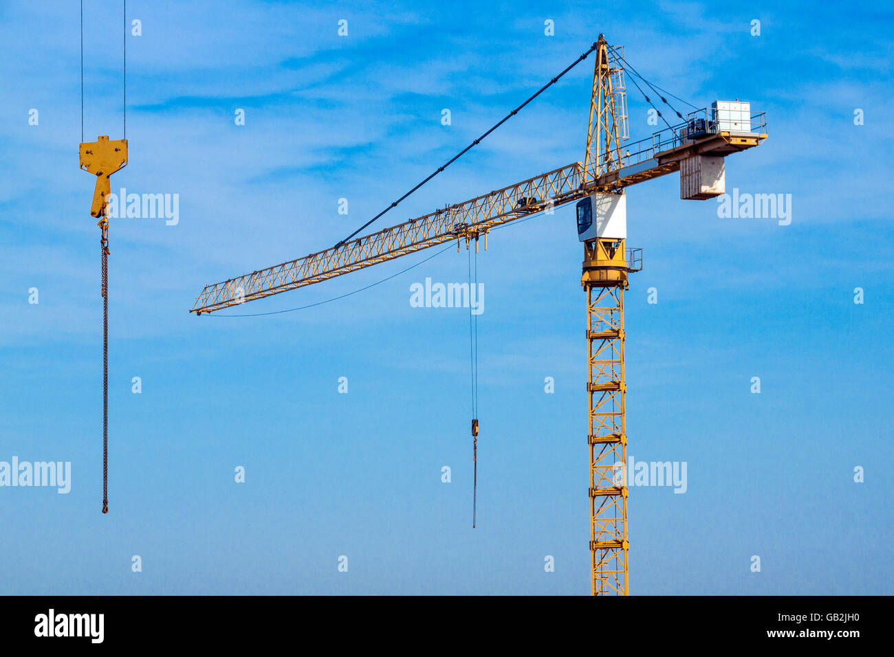 Close up di giallo sollevamento elevato per impieghi pesanti gru e cabina di controllo e cielo blu accanto a seconda paranco pensile Foto Stock