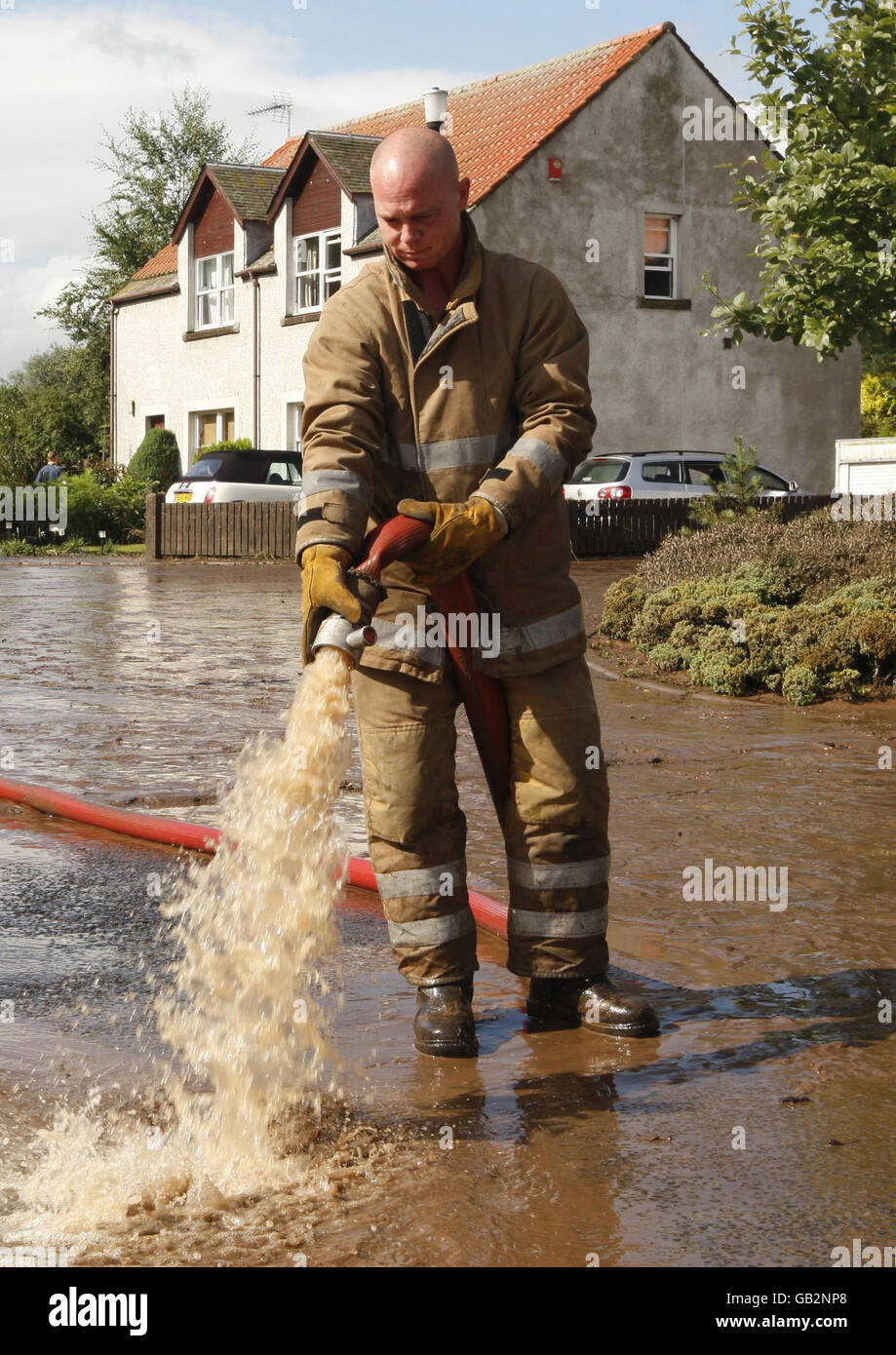 Gli equipaggi dei vigili del fuoco lavorano per pompare via le acque alluvionali nel villaggio di Freuchie, Fife, Scozia, a seguito di piogge torrenziali. Foto Stock