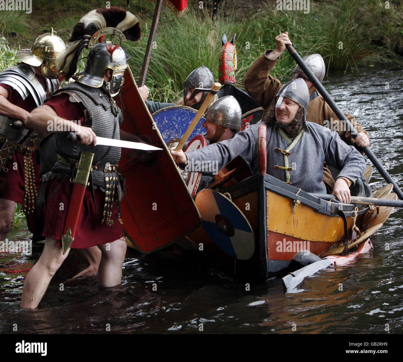 Gli appassionati del National Living History Festival di Lankark Loch in Scozia rievocano una scena storica come i predatori vichinghi in uno scontro tra navi da diporto e soldati romani. Foto Stock