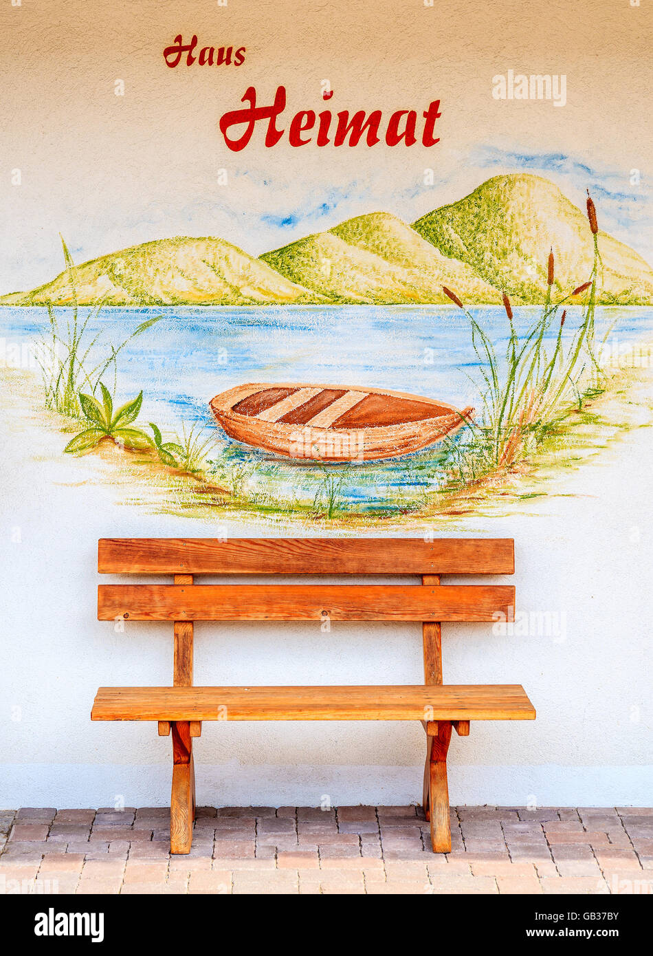 Lago Weissensee, Austria - Lug 6, 2015: panca in legno nella parte anteriore di un dipinto su una tipica casa alpina. Campagna austriaca case Foto Stock