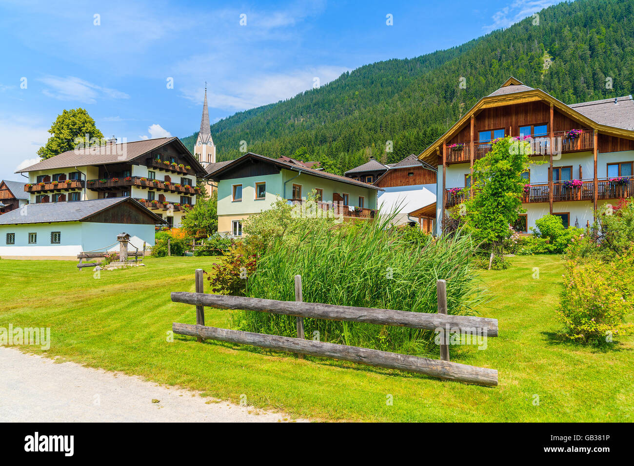 Tradizionali case di campagna nel villaggio di montagna situato sulla riva del lago Weissensee in estate il paesaggio di montagna delle Alpi, Austria Foto Stock