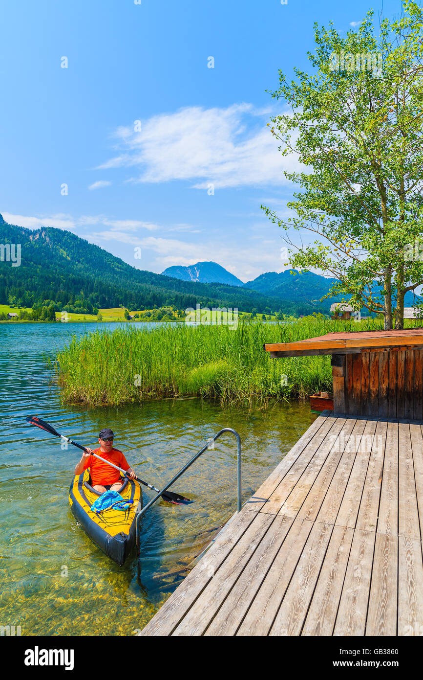 Lago Weissensee, Austria - Lug 6, 2015: un uomo in kayak sulle acque del lago Weissensee in estate il paesaggio di montagna delle Alpi, Austri Foto Stock