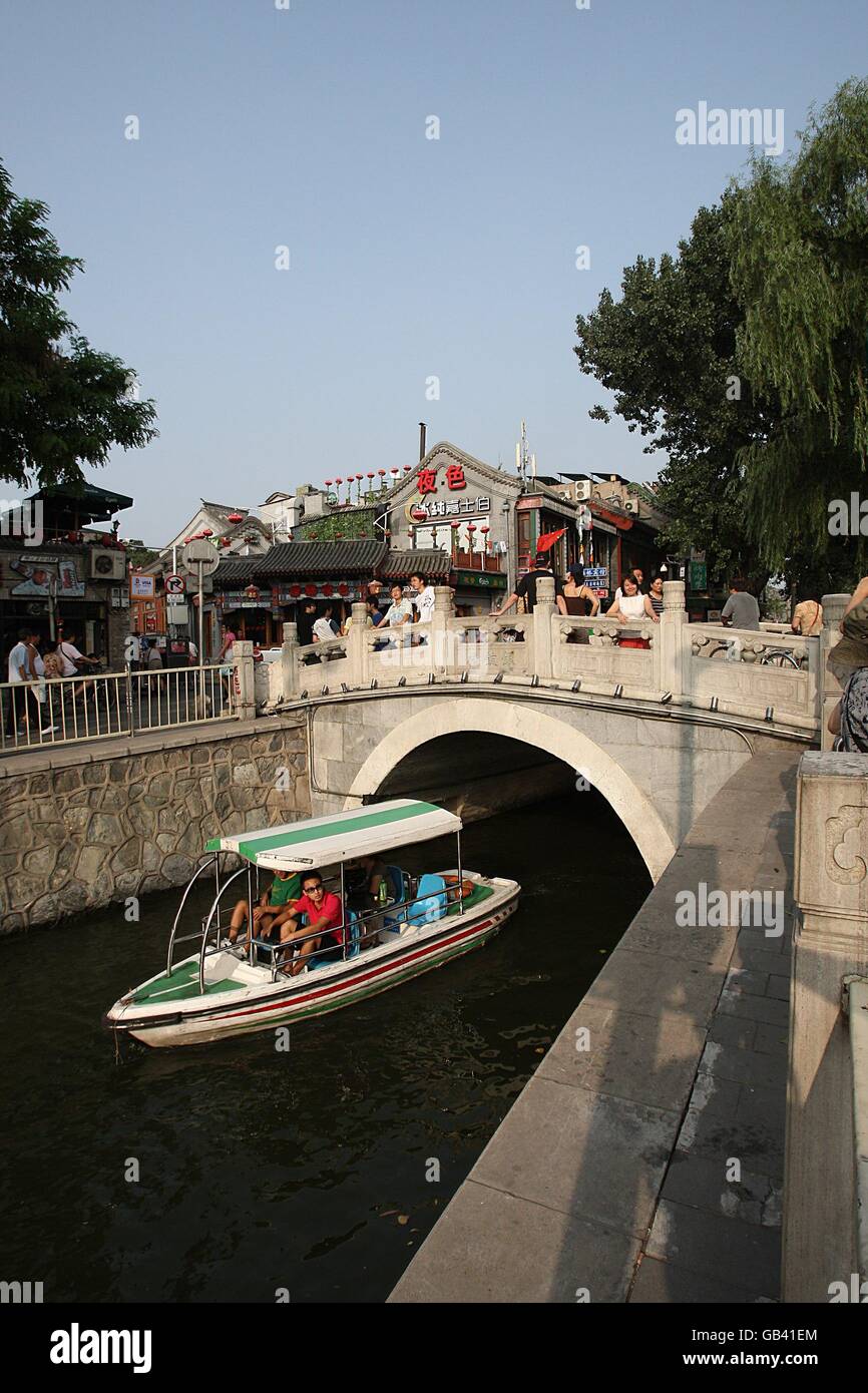 Una barca naviga sotto il ponte di Jinding, tra il lago Houhai e Qian Hai, a Pechino, in Cina. Foto Stock