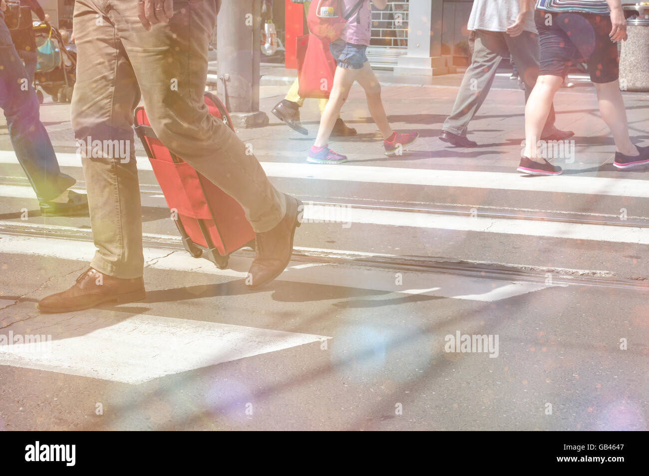 Pedoni che attraversano una strada con bokeh luci. Urban Rush Hour Foto Stock