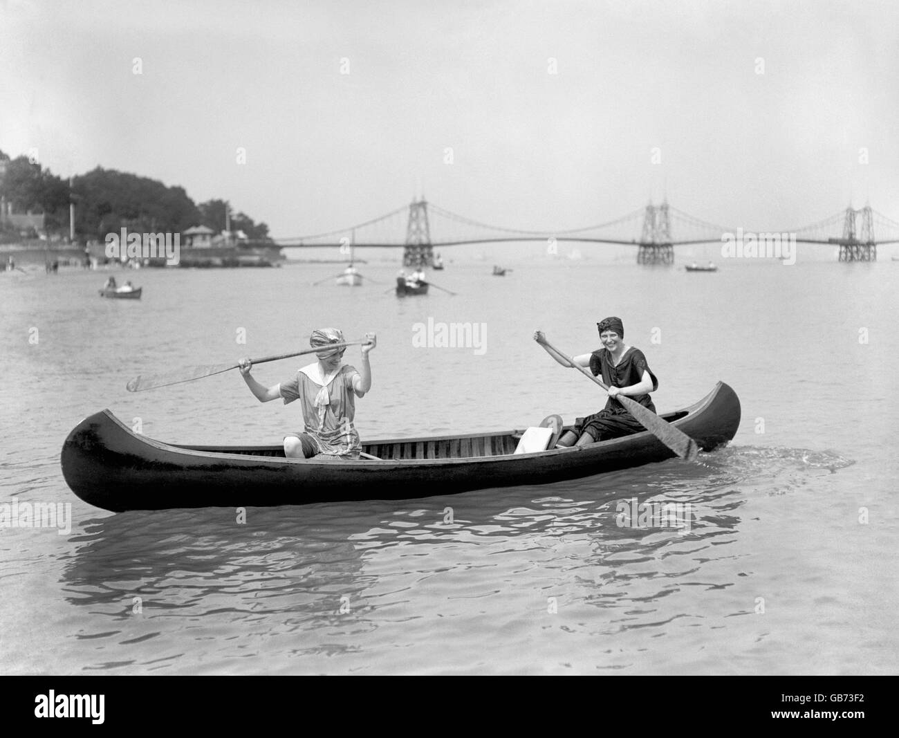 Due donne pagaiano una canoa in mare all'isola di Wight. Foto Stock